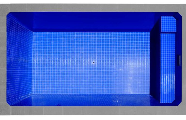 Top-down view of a rectangular plunge pool with deep blue tiled interior and built-in bench seating in Newcastle NSW