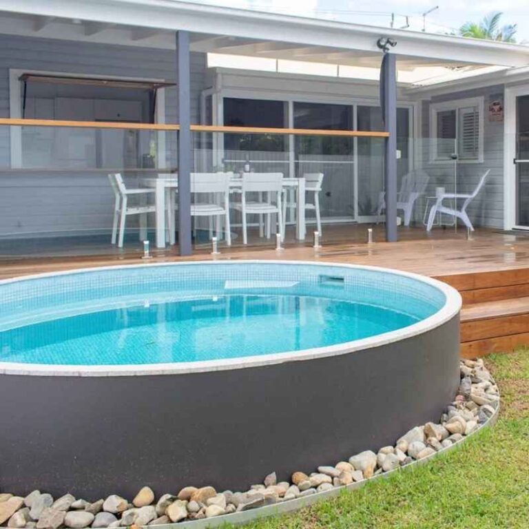 Round above ground plunge pool with tiled interior beside a timber deck and outdoor dining area in a modern backyard in Newcastle NSW