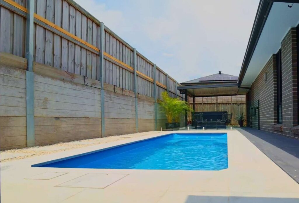 Modern fibreglass plunge pool installed in a long and narrow backyard in Bateau Bay