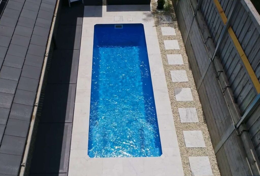 Slimline fibreglass pool design with stepping stones and narrow backyard layout in Bateau Bay