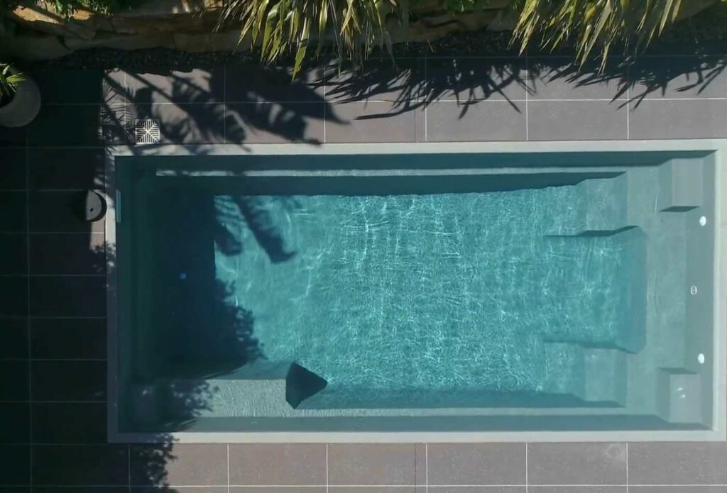 Top-down aerial view of a modern fibreglass plunge pool with built-in bench seating and tiled surrounds in Gosford