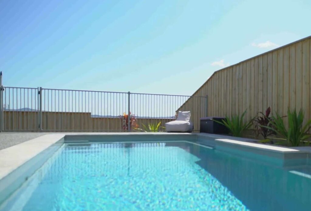 Low-angle view of a contemporary fibreglass pool with crystal-clear water and scenic hillside outlook in Maitland