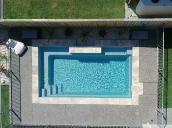 Aerial top-down view of a rectangular fibreglass swimming pool with entry steps and clean geometric design