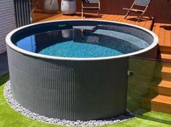 Round above ground plunge pool with ribbed exterior beside a timber deck and outdoor seating area in a modern backyard in Newcastle NSW